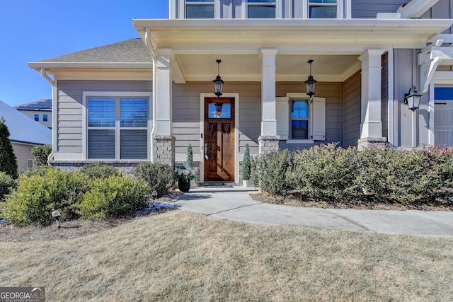 view of exterior entry featuring covered porch