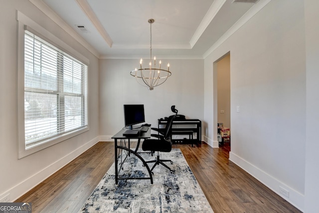 home office with dark hardwood / wood-style flooring, a notable chandelier, ornamental molding, and a raised ceiling