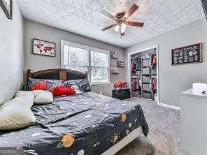 bedroom with a closet, ceiling fan, and a textured ceiling