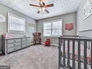 bedroom with ceiling fan and a textured ceiling