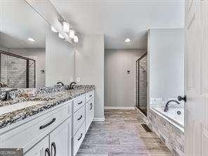 bathroom with vanity and separate shower and tub