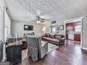 living room featuring ceiling fan and dark hardwood / wood-style flooring