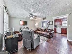 living room with dark wood-type flooring and ceiling fan