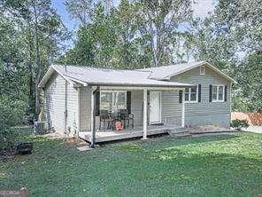 ranch-style home with covered porch and a front yard