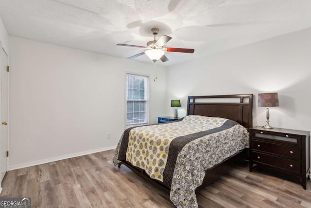 bedroom featuring baseboards, a ceiling fan, and wood finished floors
