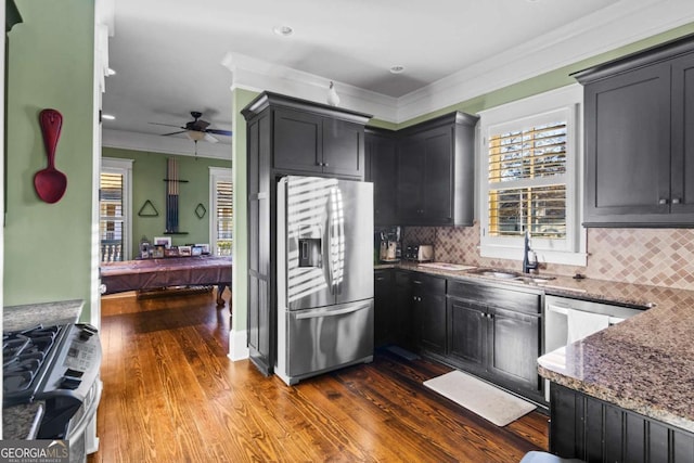 kitchen featuring stainless steel appliances, tasteful backsplash, sink, hardwood / wood-style flooring, and stone counters