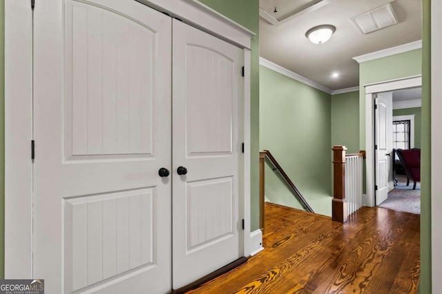 hallway with hardwood / wood-style flooring and ornamental molding