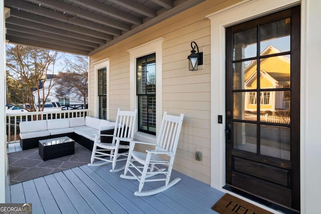 wooden terrace with covered porch and outdoor lounge area