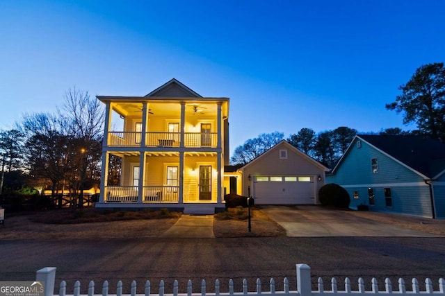 view of front facade with covered porch, ceiling fan, a balcony, and a garage