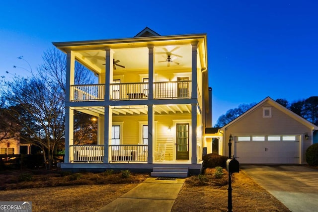 view of front facade with covered porch, ceiling fan, a balcony, and a garage