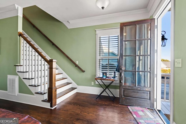 foyer entrance with crown molding and dark hardwood / wood-style flooring