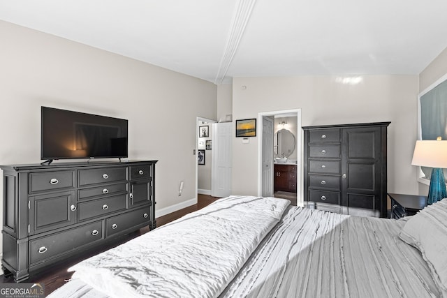 bedroom with ensuite bathroom and dark hardwood / wood-style floors