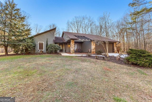 single story home with a garage and a front lawn