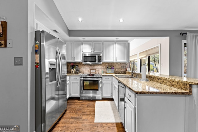 kitchen featuring light stone countertops, appliances with stainless steel finishes, white cabinetry, sink, and dark hardwood / wood-style floors