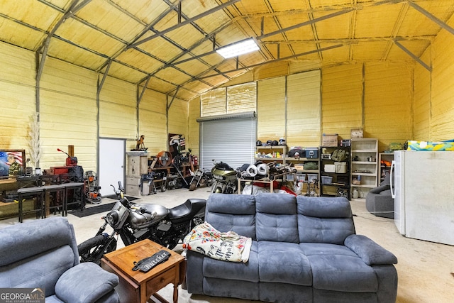 garage with a workshop area and white fridge