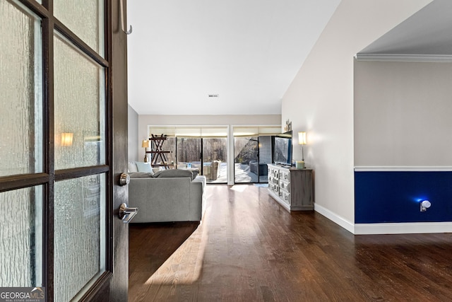 unfurnished living room featuring dark hardwood / wood-style flooring and crown molding