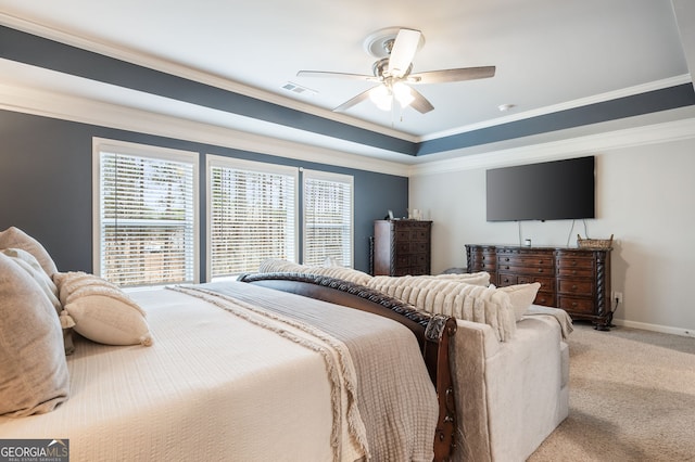 bedroom featuring a raised ceiling, crown molding, light colored carpet, and ceiling fan