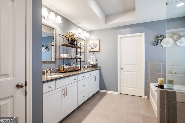 bathroom with vanity, a tub to relax in, and tile patterned flooring