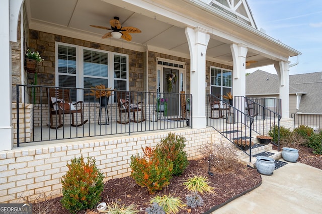 view of exterior entry with ceiling fan and covered porch