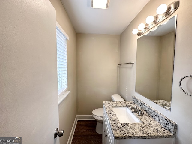 bathroom featuring plenty of natural light, hardwood / wood-style floors, toilet, and vanity