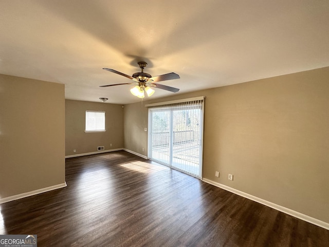 empty room with ceiling fan and dark hardwood / wood-style flooring