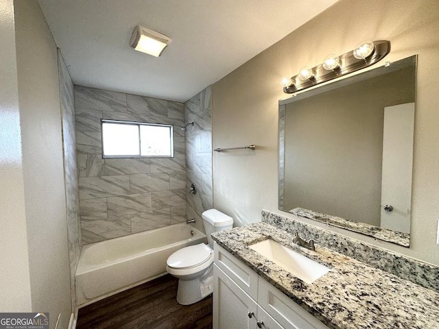 full bathroom featuring tiled shower / bath combo, wood-type flooring, toilet, and vanity