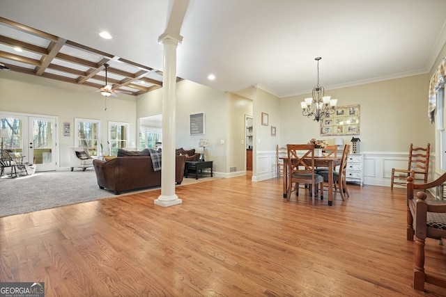 dining space featuring ornate columns, coffered ceiling, light hardwood / wood-style flooring, beam ceiling, and plenty of natural light