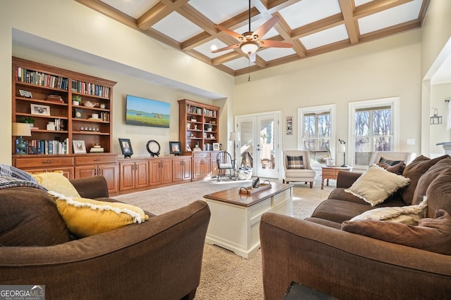 living room featuring coffered ceiling, light carpet, french doors, a high ceiling, and beam ceiling