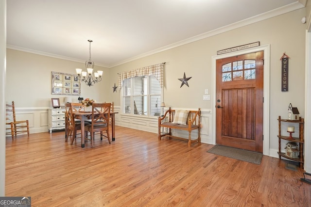 dining room with a chandelier, a healthy amount of sunlight, ornamental molding, and light hardwood / wood-style floors