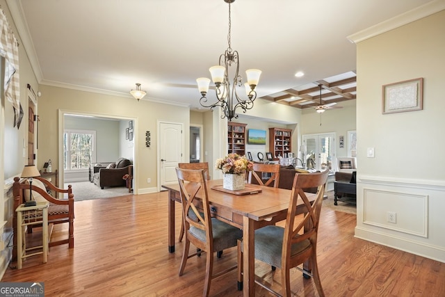 dining room featuring beamed ceiling, coffered ceiling, light wood-type flooring, ornamental molding, and ceiling fan