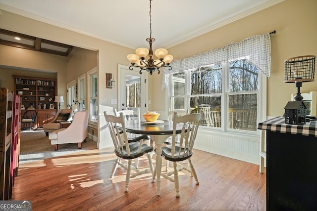 dining room featuring a notable chandelier, ornamental molding, and light hardwood / wood-style floors