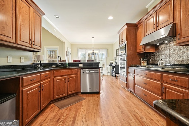 kitchen featuring appliances with stainless steel finishes, sink, light hardwood / wood-style flooring, ornamental molding, and backsplash