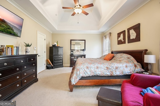 bedroom with ceiling fan, light colored carpet, a tray ceiling, and ornamental molding