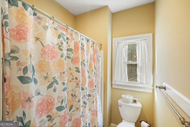 bathroom featuring curtained shower and toilet