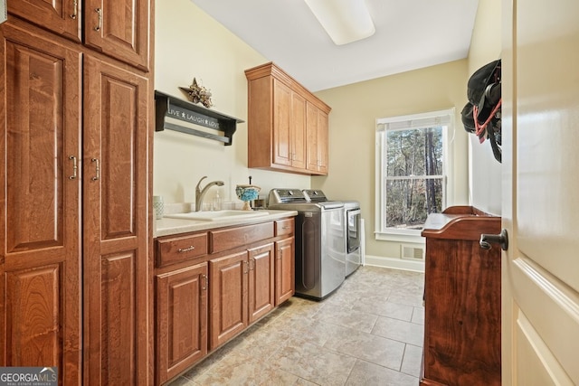 laundry room featuring cabinets, sink, and independent washer and dryer