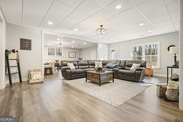 living room featuring hardwood / wood-style flooring and a drop ceiling