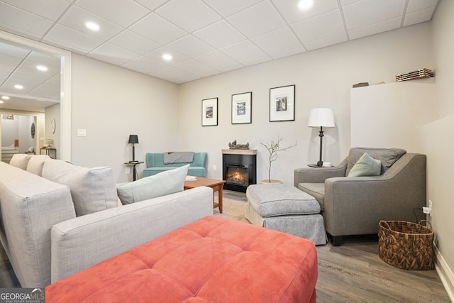 living room featuring hardwood / wood-style flooring and a paneled ceiling