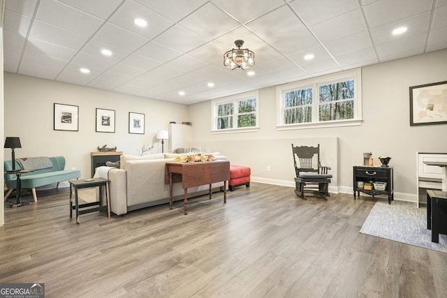 living room featuring a drop ceiling and light hardwood / wood-style flooring