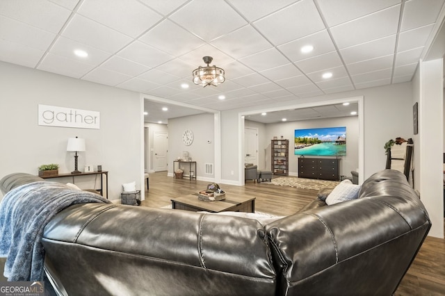 living room with hardwood / wood-style flooring and a drop ceiling