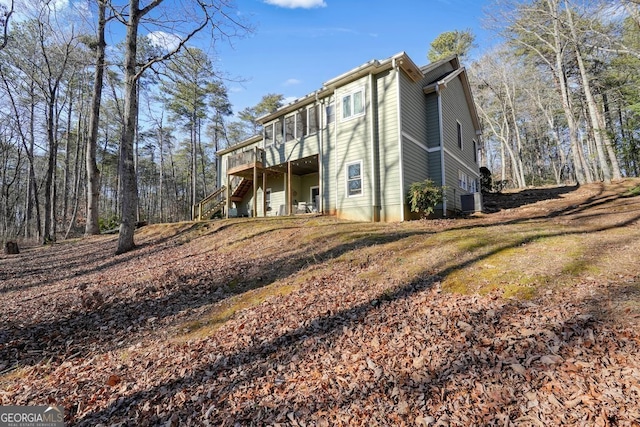 view of side of property with a deck and central AC