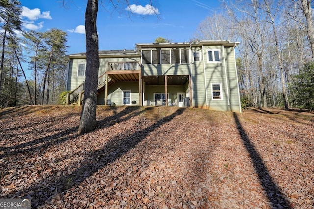 back of property featuring a deck and a sunroom