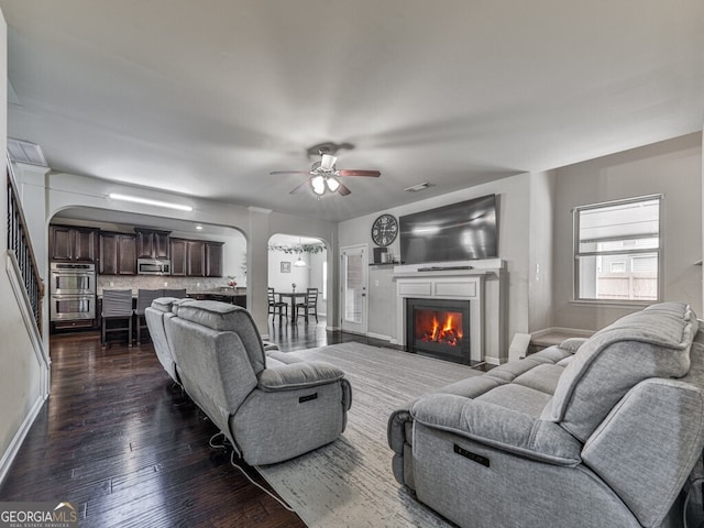 living room with ceiling fan and dark hardwood / wood-style floors