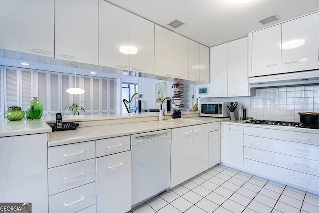 kitchen featuring light tile patterned flooring, sink, white cabinets, decorative backsplash, and white appliances