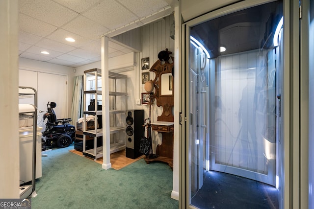 interior space with a paneled ceiling and carpet