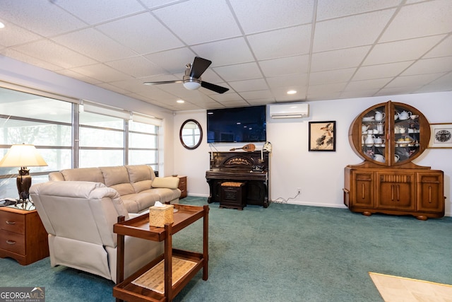 living room featuring a paneled ceiling, carpet flooring, a wall mounted AC, and ceiling fan