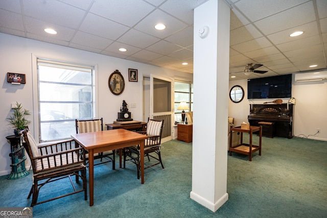 dining area featuring a paneled ceiling, a wall unit AC, ceiling fan, and carpet flooring