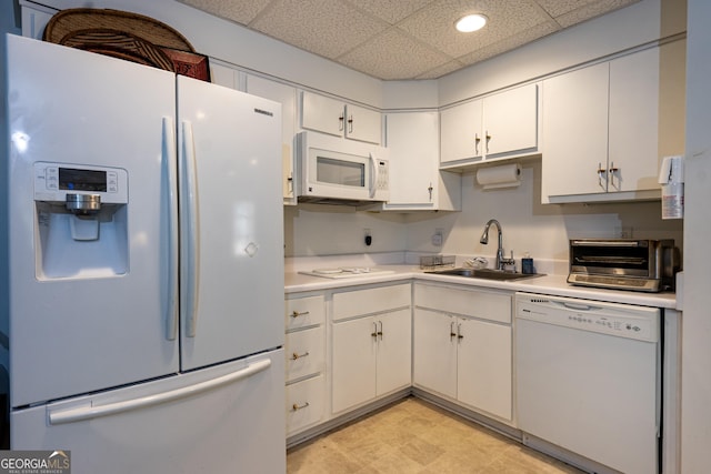 kitchen featuring sink, white appliances, a paneled ceiling, and white cabinets