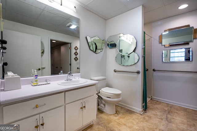 bathroom with vanity, a drop ceiling, and toilet