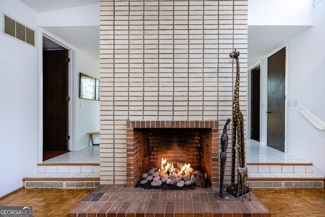 room details featuring parquet flooring and a brick fireplace