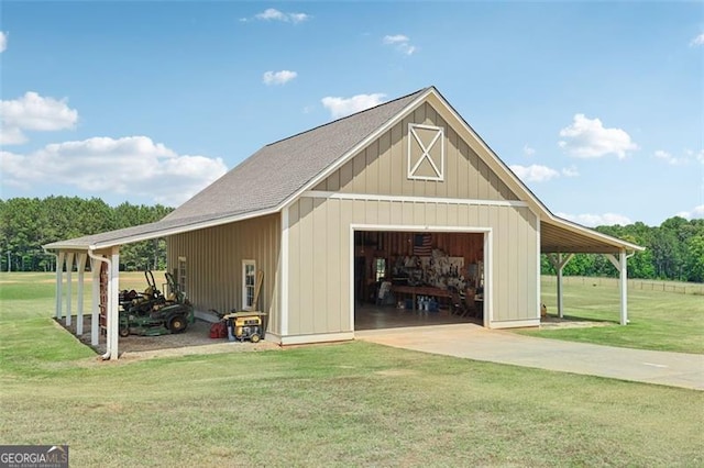 view of outdoor structure with a carport, a garage, and a yard